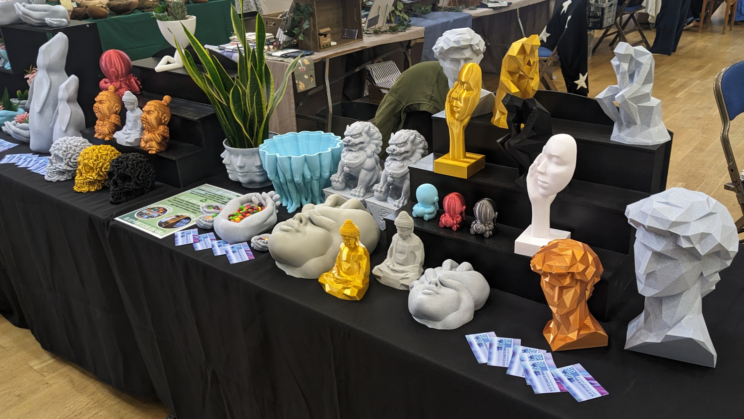 Table full of 3D printed products and gifts from BluPrints3D, showcasing a wide range of unique 3D printed items available to buy